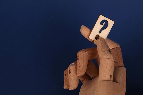 Wooden Hand Holding a Question Mark
