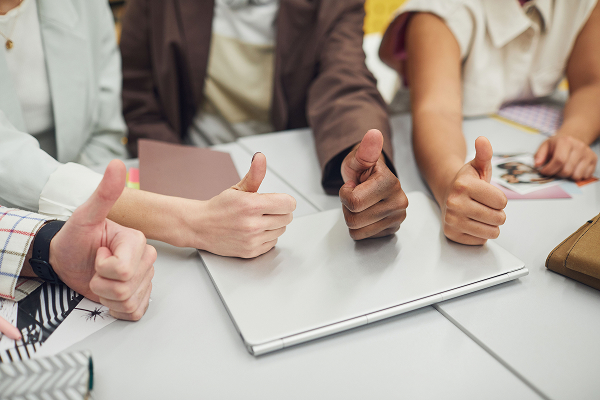 peoples hands gesturing a thumbs up