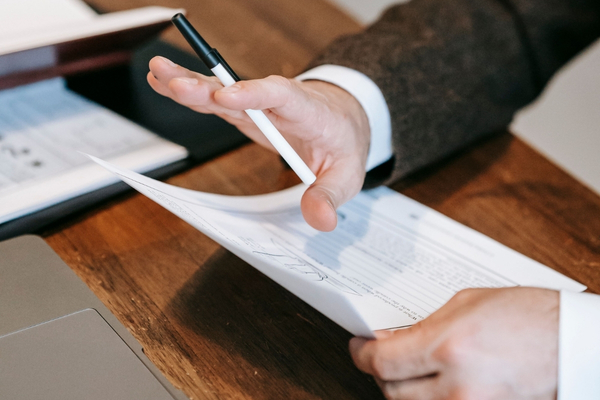 photo-of-man-holding-pen-and-paper